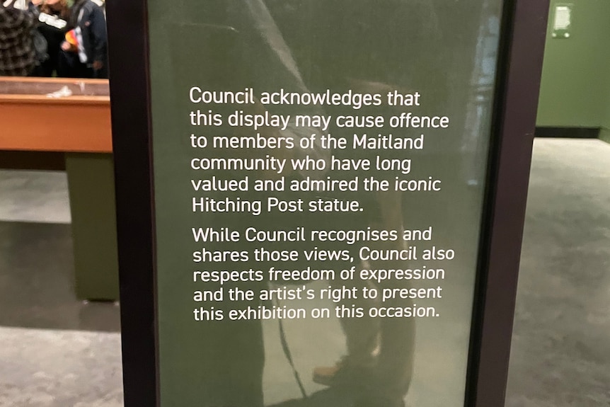 A warning sign placed in front of an art exhibition.