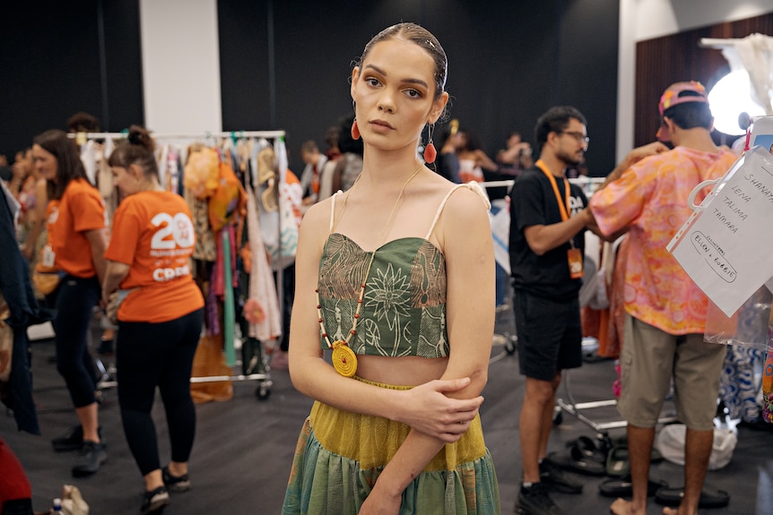 A model posing backstage at a runway show.