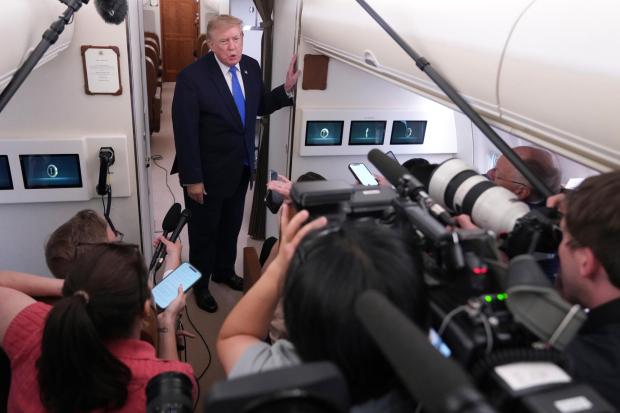 President Donald Trump speaks to reporters onboard Air Force One.