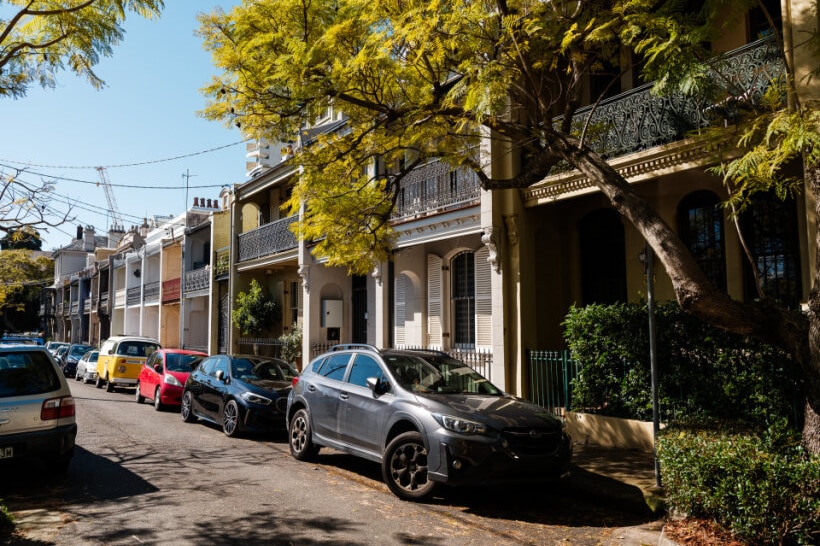 Terraces on street with cars and gates visible