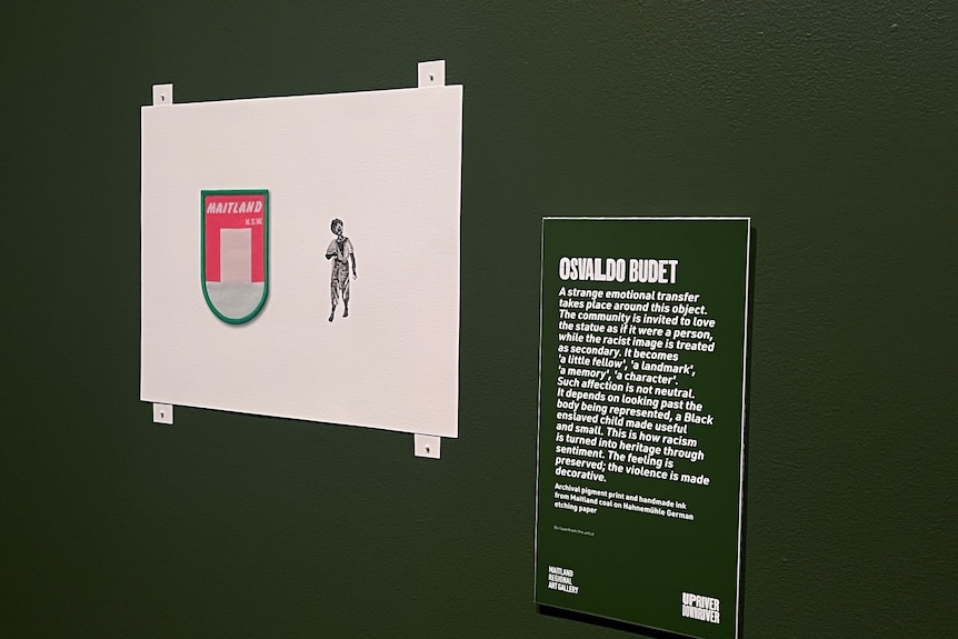 A drawing hanging on a wall which depicts a young african american boy next to a maitland badge