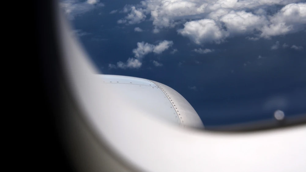The clouds and sky outside an airplane window.
