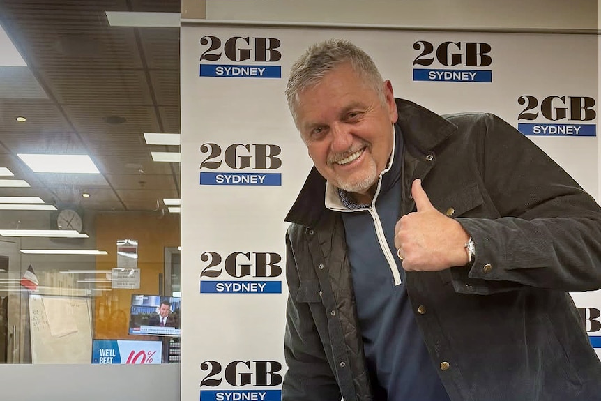tay hadley from 2gb radio standing inside a radio studio doing a thumbs up