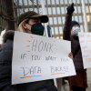 A protester with a sign saying “HONK IF YOU WANT YOUR DATA BACK!!!” stands with other demonstrators outside of the U.S. Office of Personnel Management’s headquarters in February in Washington, D.C., to rally against the DOGE team set up by President Trump’s billionaire adviser Elon Musk getting access to personal data about federal employees.