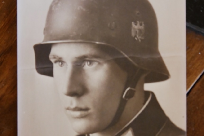 A sombre-faced man in a World War Two soldier's uniform