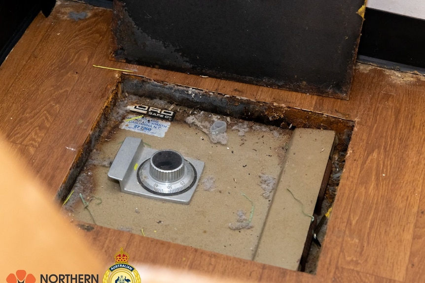 A combination safe is sunk into a hole cut in the wooden floorboards.