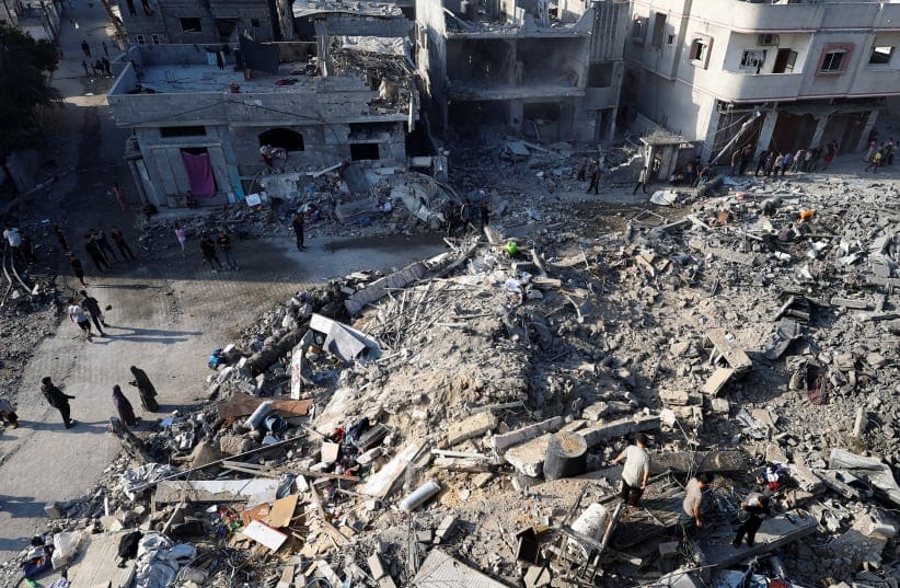 Palestinians inspect the site of an Israeli strike on a house that was pre-warned by the Israeli military to evacuate before the strike was carried out late on Wednesday, in Al-Nuseirat refugee camp, in the central Gaza Strip, July 16, 2026.