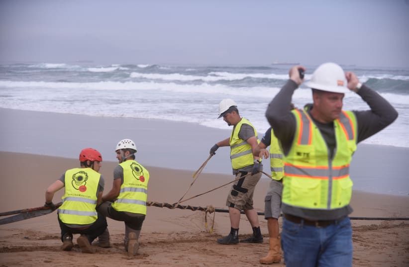 Workers operate on a lead line connected to fiber optic cable at Arrietara beach, near Bilbao, northern Spain, June 13, 2017, as Facebook Inc. and Microsoft Corp. join forces to build an underwater fiber optic cable across the Atlantic Ocean, linking Europe and the USA.