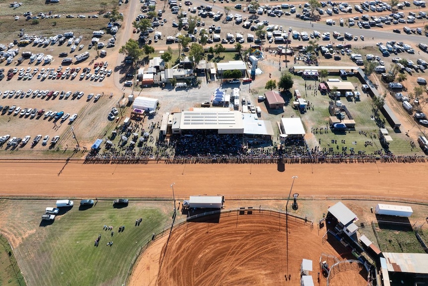 an aerial image of hundreds of caravans parked near a racecourse