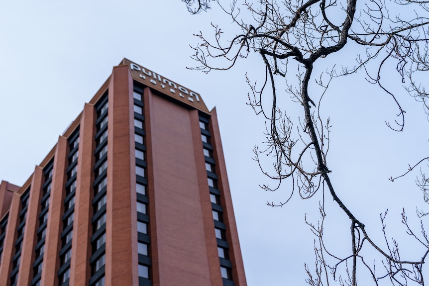 A multi-storey brick building on a partly cloudy day.