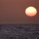 The sun setting on the horizon on the ocean