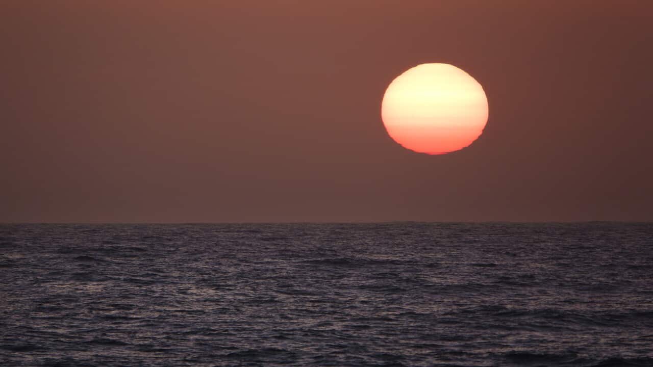 The sun setting on the horizon on the ocean